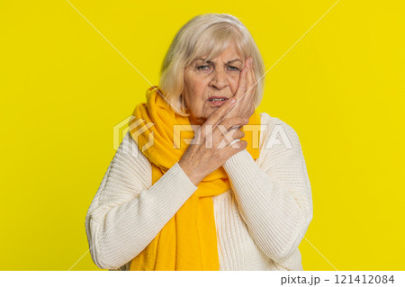 Senior woman touching cheek closing eyes with expression of terrible suffer from painful toothache 121412084