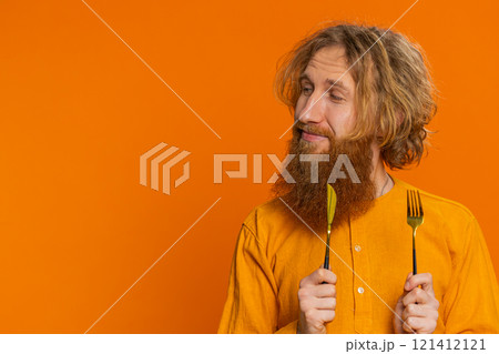 Hungry man waiting for serving dinner meal dishes with restlessness holding cutlery fork knife Hungry man waiting for serving dinner meal dishes with restlessness holding cutlery fork knife 121412121