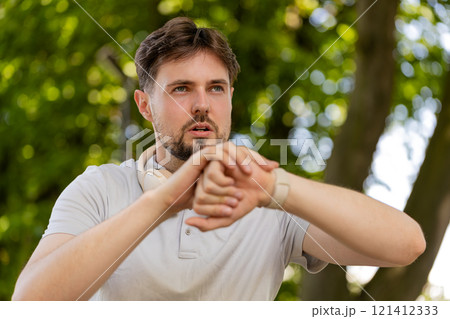 Runner man listening music via wireless headphones using smartwatch for training ready for race 121412333