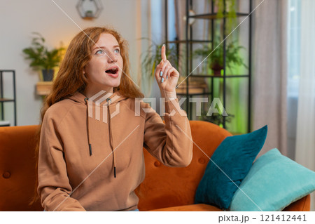 Thoughtful inspired woman make positive gesture raises finger came up with creative idea at home 121412441