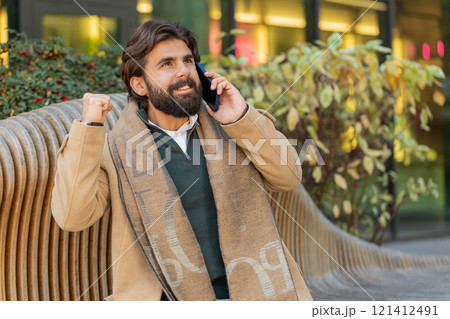 Happy surprised man involved in pleasant conversation phone call good news enjoying talking gossip 121412491
