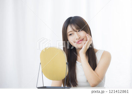 鏡を見て肌を気にする若い女性 鏡を見て肌を気にする若い女性 121412861