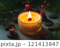 a beautiful scented candle in a transparent holder burns on a dark background. High quality photo 121413847