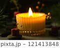 a beautiful scented candle in a transparent holder burns on a dark background. High quality photo 121413848