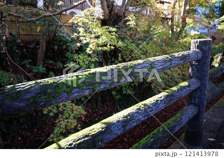 川への落下防止用の木に似せたコンクリート製の柵 古くなって苔が生えている 川への落下防止用の木に似せたコンクリート製の柵 古くなって苔が生えている 121413978