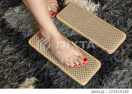 Woman's foot stands on nails on sadhu board during meditation class Woman's foot stands on nails on sadhu board during meditation class 121414180
