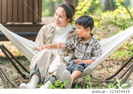 キャンプ場のハンモックで遊ぶ家族・ファミリー（アウトドア・旅行・レジャー・ピクニック） 121414418