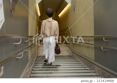 地下鉄の階段を下りる女性 121414666