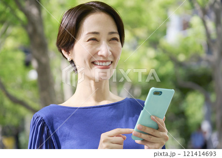 公園でスマホを持つ女性 公園でスマホを持つ女性 121414693