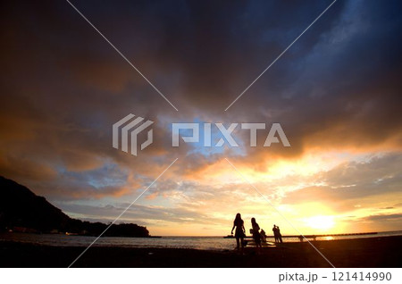 海の夕陽を見る女性のシルエット 121414990