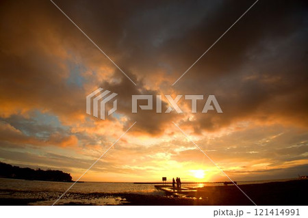 海の夕陽を見る人々のシルエット 121414991
