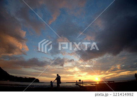 夕暮れの浜辺を歩く人のシルエット 121414992