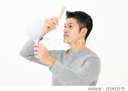 鏡を見て髪を気にする男性 121415170