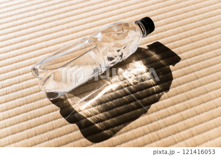 太陽光が差し込む場所に置かれた水の入ったペットボトル　収れん現象 121416053