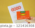 手に持ったお薬手帳と診察券 121416308