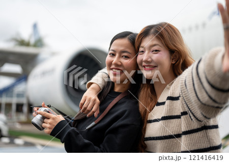 Two female friends, excited for their trip together, are enjoying taking a selfie at the airport. Two female friends, excited for their trip together, are enjoying taking a selfie at the airport. 121416419