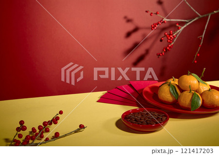 Tet theme photograph with new year dishes, red envelope and red decorative flower branches, featured on red background. Blank space on yellow countertop for product displaying Tet theme photograph with new year dishes, red envelope and red decorative flower branches, featured on red background. Blank space on yellow countertop for product displaying 121417203