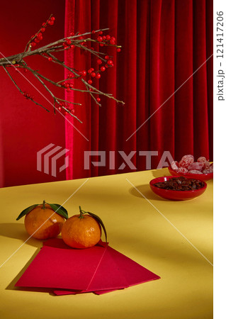 Oriental new year photography on red background. Blank space on yellow table top for product presentation, fresh fruit and Tet decorative items displayed around Oriental new year photography on red background. Blank space on yellow table top for product presentation, fresh fruit and Tet decorative items displayed around 121417206