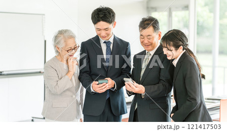 スマホを使う高齢者と若いビジネスマン(家族経営・後継者・事業継承・跡取り・売却・買収・世代交代) スマホを使う高齢者と若いビジネスマン(家族経営・後継者・事業継承・跡取り・売却・買収・世代交代) 121417503