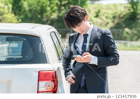 自動車を降りてスマホを見ながら考える若いアジア人ビジネスマン(トラブル・ロードサービス・自動車保険) 自動車を降りてスマホを見ながら考える若いアジア人ビジネスマン(トラブル・ロードサービス・自動車保険) 121417930