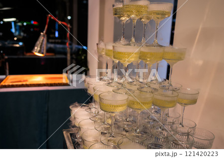 Towering pyramid of champagne glasses filled with bubbly 121420223