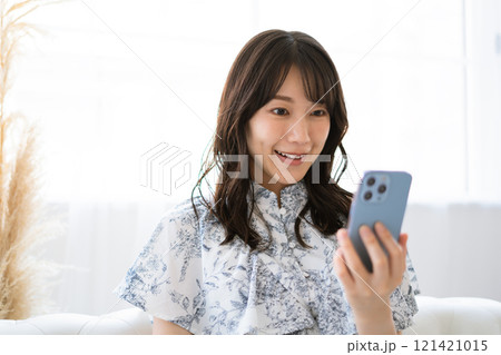 スマホを持つ黒髪ロングヘアの若い女性 スマホを持つ黒髪ロングヘアの若い女性 121421015