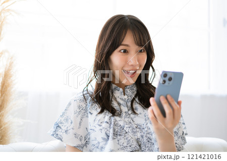 スマホを持つ黒髪ロングヘアの若い女性 121421016
