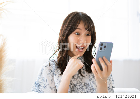スマホを持つ黒髪ロングヘアの若い女性 スマホを持つ黒髪ロングヘアの若い女性 121421021