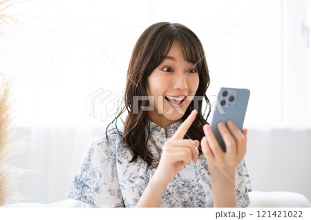 スマホを持つ黒髪ロングヘアの若い女性 スマホを持つ黒髪ロングヘアの若い女性 121421022