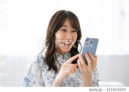 スマホを持つ黒髪ロングヘアの若い女性 スマホを持つ黒髪ロングヘアの若い女性 121421024