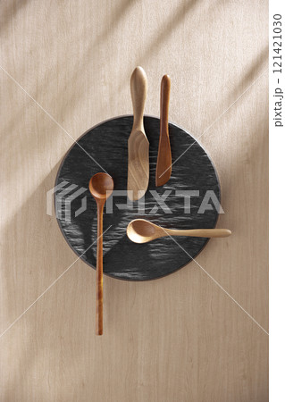 Various tableware on a soft wood-toned table background with sunlight shining through. Various tableware on a soft wood-toned table background with sunlight shining through. 121421030