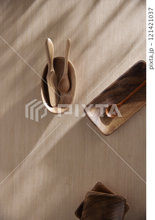 Various tableware on a soft wood-toned table background with sunlight shining through. Various tableware on a soft wood-toned table background with sunlight shining through. 121421037