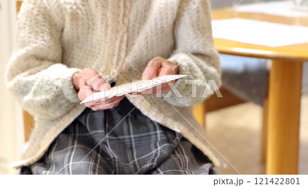 年賀状の宛名を見る高齢女性の手元 年賀状の宛名を見る高齢女性の手元 121422801