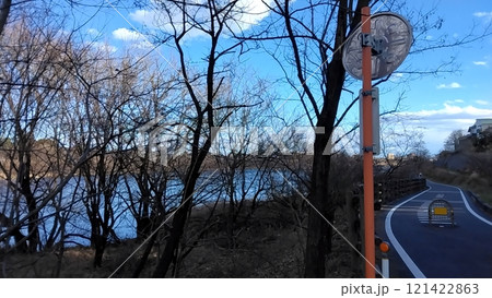 秋の木々が川を覆うサイクリングロード 121422863