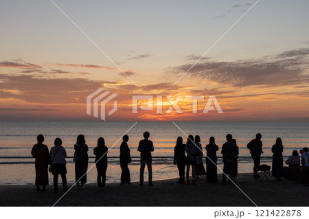 〈島根県〉稲佐の浜で海に沈む夕日を眺める観光客 121422878