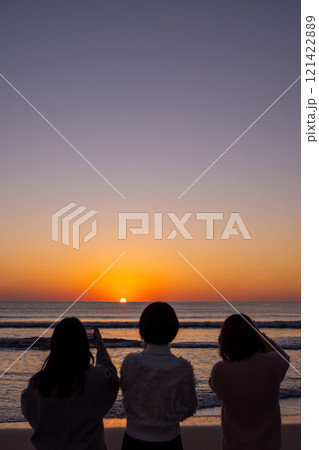 〈島根県〉稲佐の浜で海に沈む夕日を眺める観光客 〈島根県〉稲佐の浜で海に沈む夕日を眺める観光客 121422889