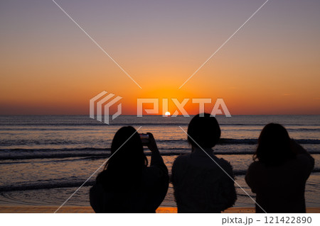 〈島根県〉稲佐の浜で海に沈む夕日を眺める観光客 〈島根県〉稲佐の浜で海に沈む夕日を眺める観光客 121422890