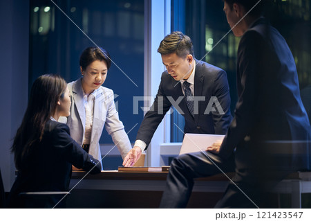 asian project team working late together meeting in office 121423547