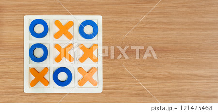 A game of Tic-Tac-To on a wooden table for fun entertainment. A game of Tic-Tac-To on a wooden table for fun entertainment. 121425468
