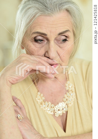 Portrait of a sad elderly woman posing at home 121425818