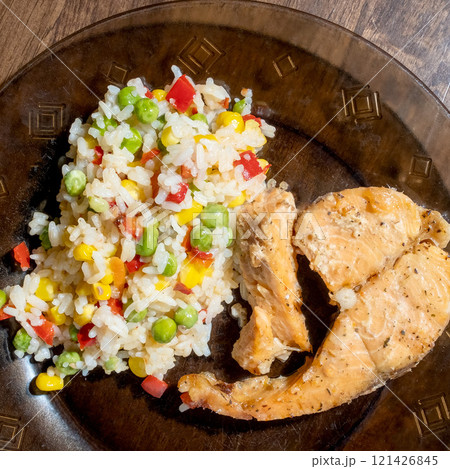 rice, vegetables and fish on dark plate 121426845