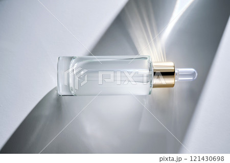 Bottle of face serum with a pipette with a beautiful highlight. Bottle of face serum with a pipette with a beautiful highlight. 121430698