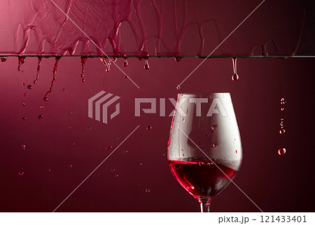 Red wine flows down into a glass. Red wine flows down into a glass. 121433401