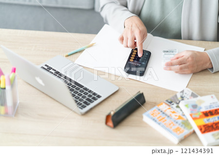 スマホで確定申告をする若い男性　顔無し 121434391