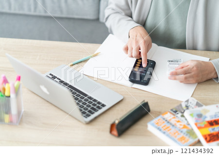 スマホで確定申告をする若い男性　顔無し 121434392