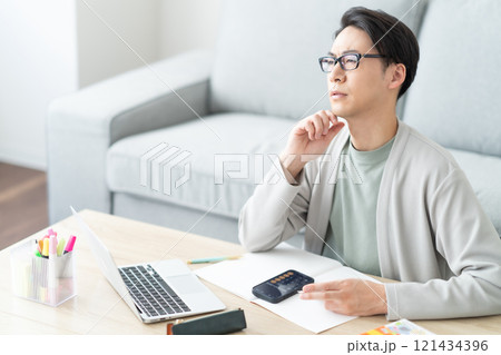 確定申告の仕分けに悩む若い男性 確定申告の仕分けに悩む若い男性 121434396