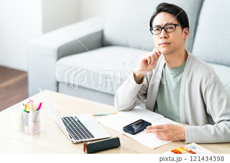 確定申告の仕分けに悩む若い男性 121434398