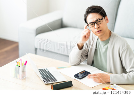 確定申告の仕分けに悩む若い男性 確定申告の仕分けに悩む若い男性 121434399