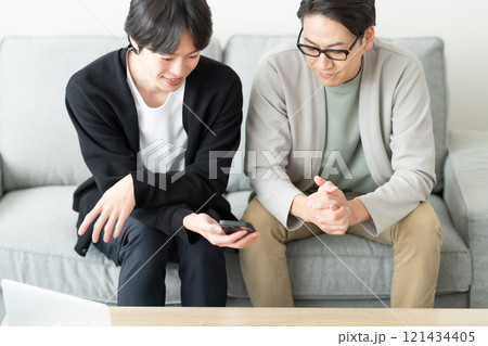 スマホを見ながら談笑する若い男性 スマホを見ながら談笑する若い男性 121434405