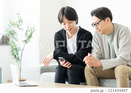 スマホを見ながら談笑する若い男性 スマホを見ながら談笑する若い男性 121434407